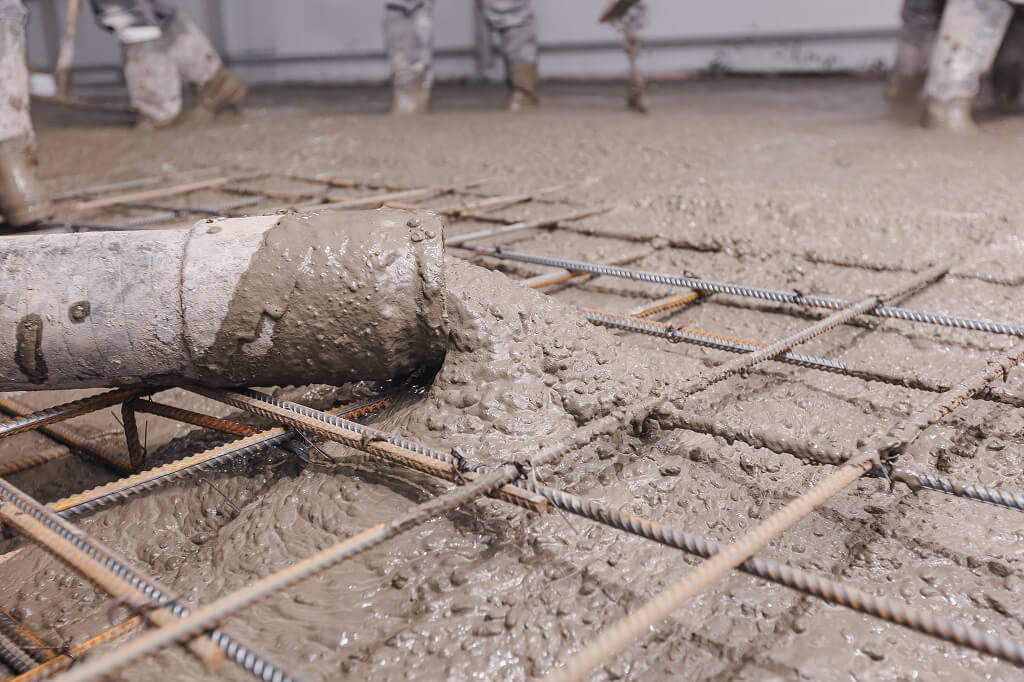 Izlivanje betona preko armature na gradilištu